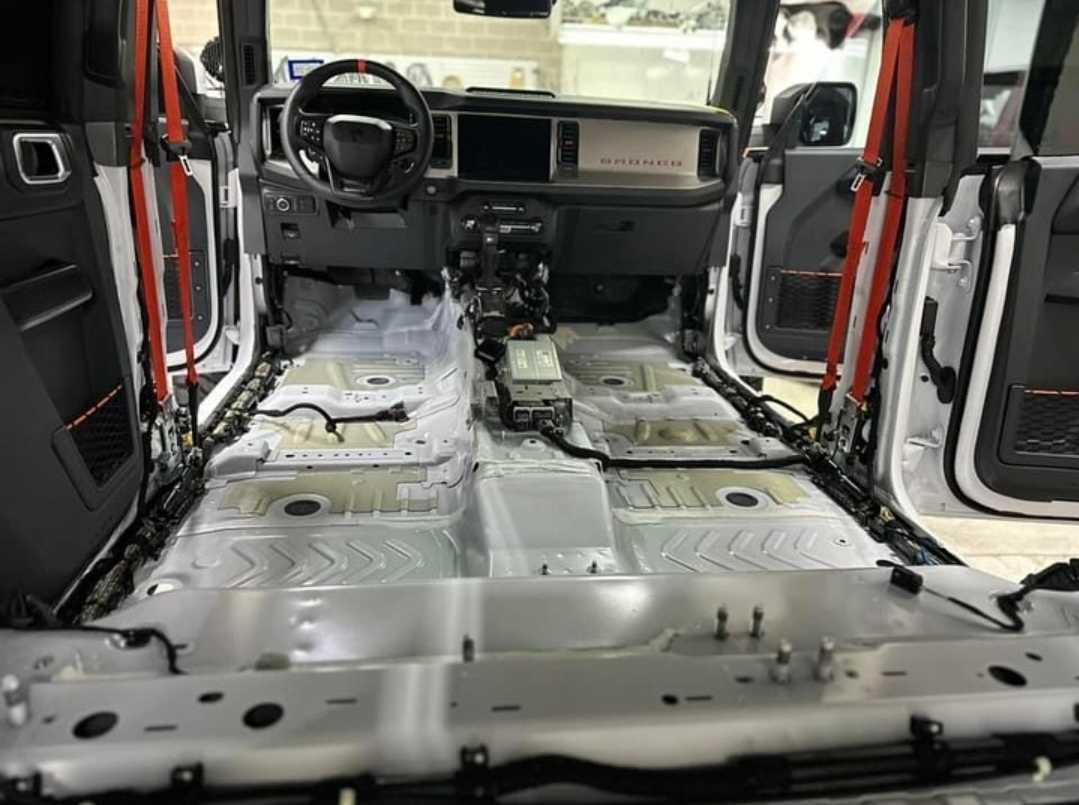 Ford Bronco with interior panels and seats removed for sound deadening prep