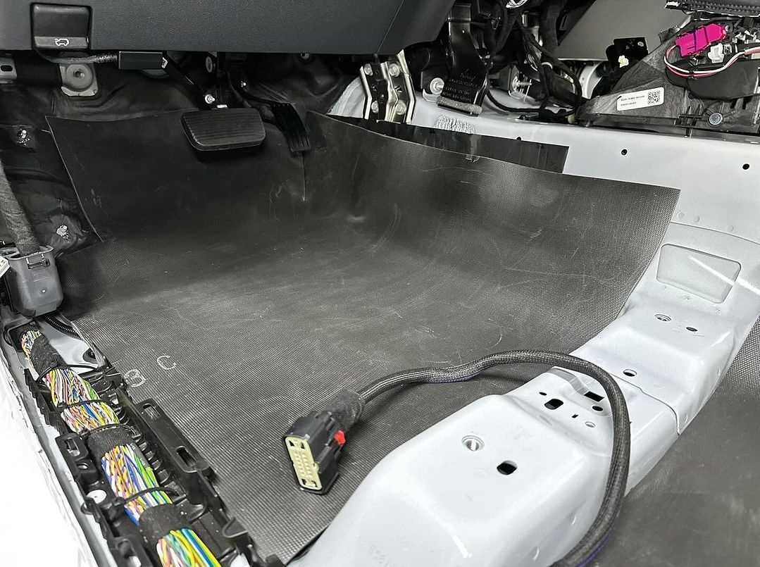 Mass loaded vinyl being laid over sound deadening on the Ford Bronco floor