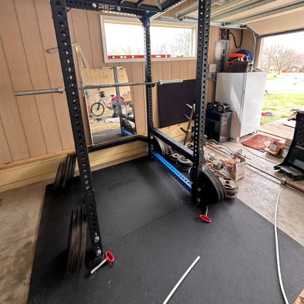 stomp mat rubber pad used under a weight rack in a garage