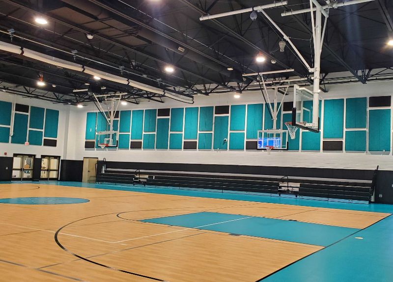 Light blue and dark grey Timberwool acoustic panels on the walls in a gym