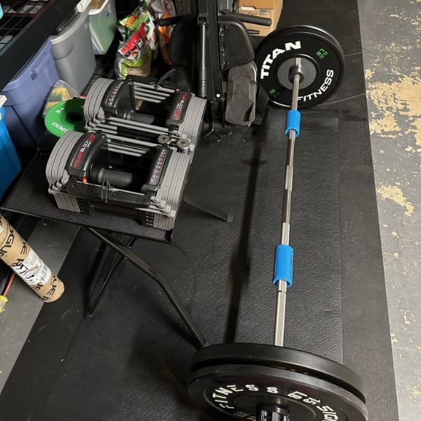 stomp mat with a barbell on it in a garage gym