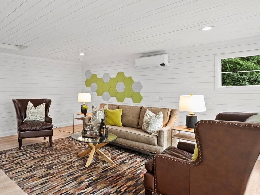 Living room with green and grey hexagon acoustic panels on white shiplap wall above sofa