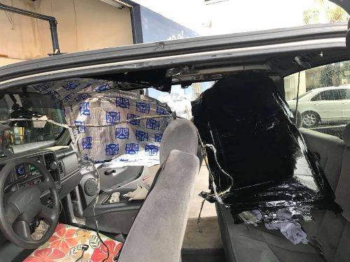 Truck cab interior stripped bare showing cheap asphalt sound deadening applied to firewall and roof, before Second Skin upgrade
