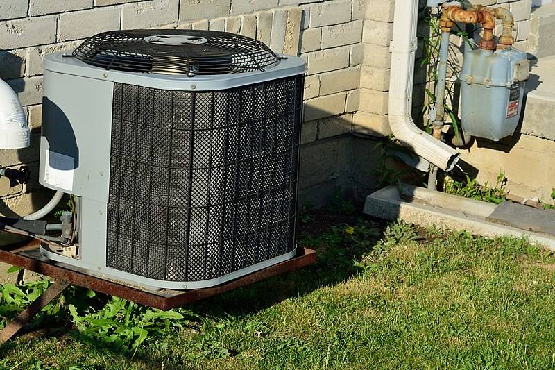 Outdoor AC condenser unit beside a house — context image for HVAC soundproofing applications