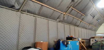 Quiet Quilt soundproof blankets lining interior walls and ceiling of a large industrial tent or warehouse structure