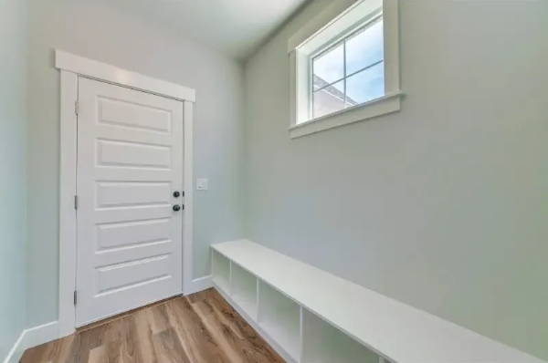 Empty mudroom entryway with interior door and bench shelving, ideal for Sound Lock door seal installation
