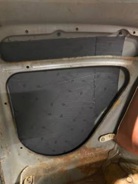Damplifier Pro sound deadening mat installed on car door quarter window panel, black foil face
