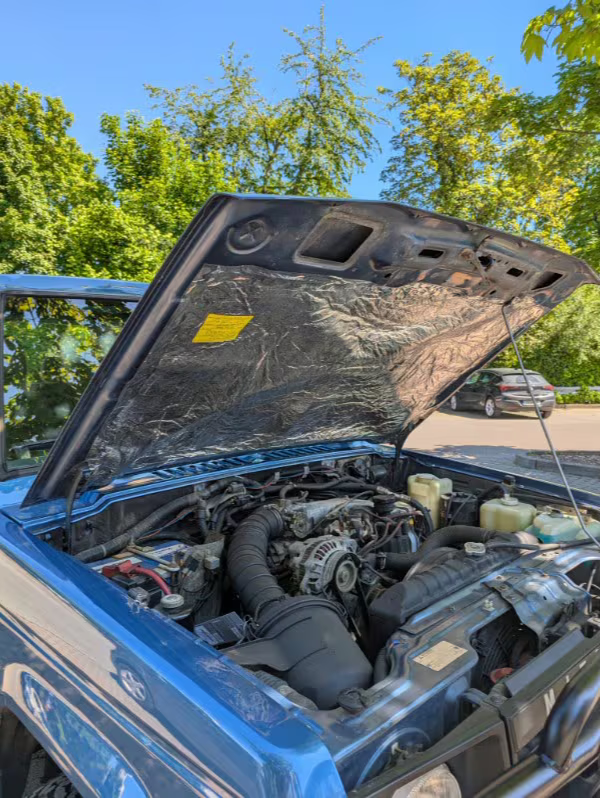 Vehicle hood open showing engine bay, Heat Wave Pro thermal insulation on hood liner