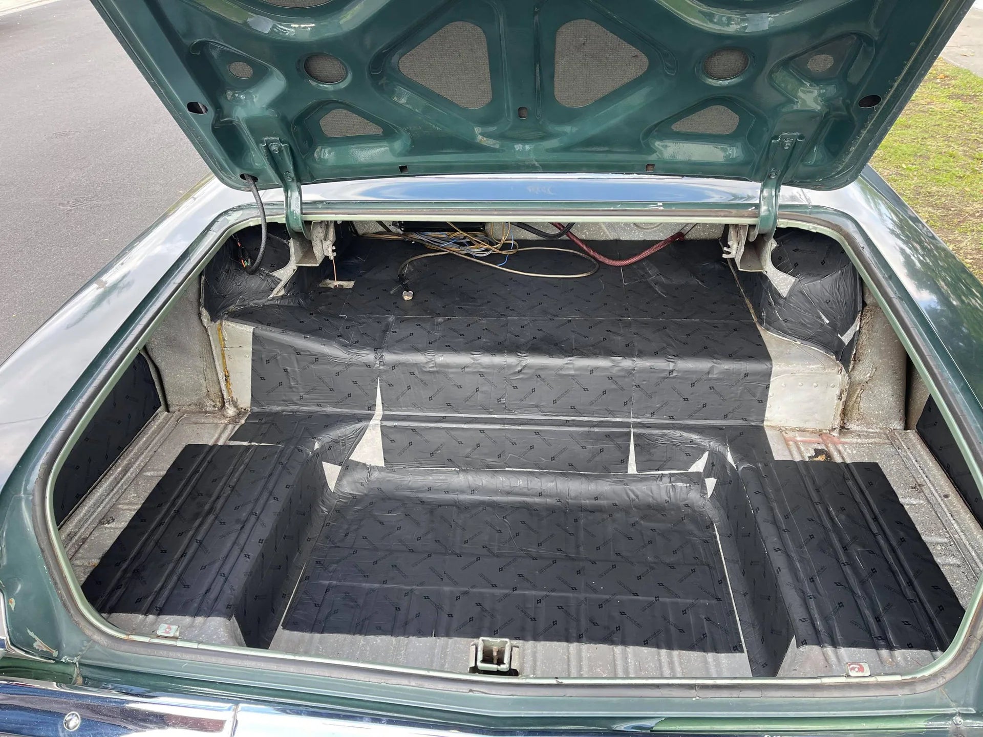 Damplifier Pro sound deadening mat installed in classic car trunk floor and wheel wells