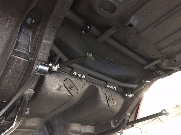 Vehicle undercarriage showing steering linkage and suspension components viewed from below